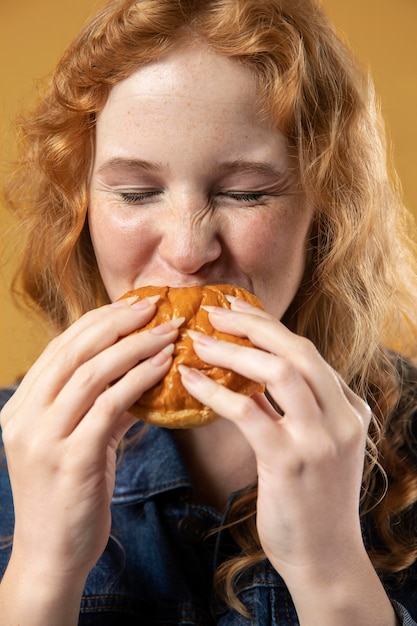 Foto gratuita mujer disfrutando comiendo una hamburguesa