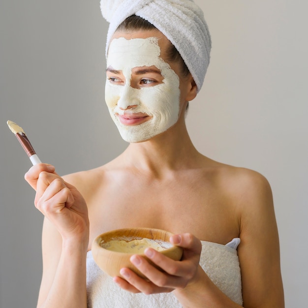 Mujer disfrutando el día de spa en casa mientras usa mascarilla