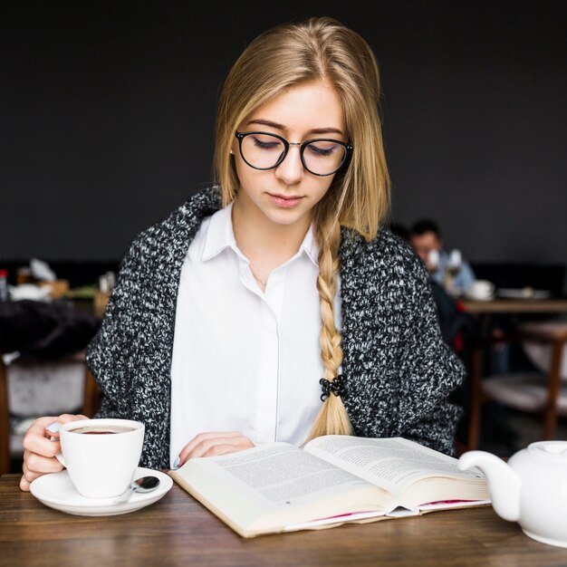 Mujer disfrutando de leer en el café