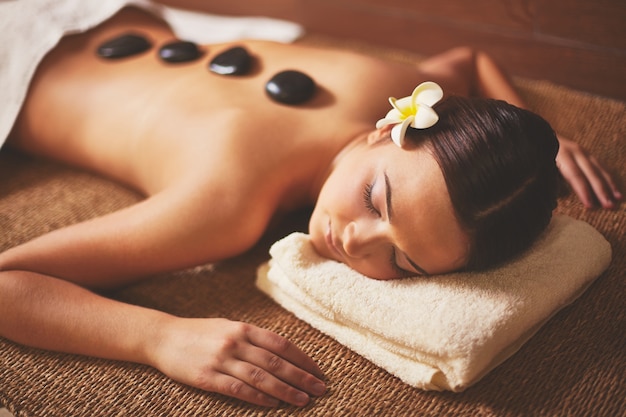 Mujer disfrutando un masaje con piedras