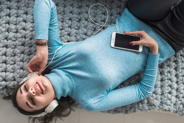 Mujer disfrutando de la música con los ojos cerrados