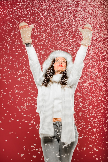 Mujer disfrutando de la nieve mientras usa ropa de invierno