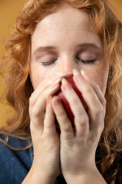 Mujer disfrutando del olor de una manzana