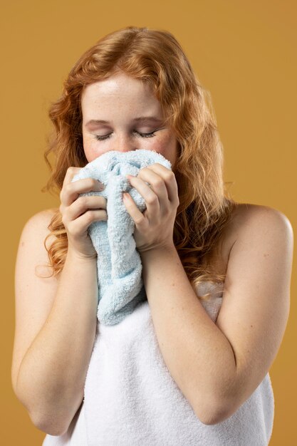 Mujer disfrutando del olor de una toalla