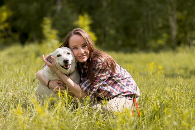 Mujer disfrutando con un perro en el campo