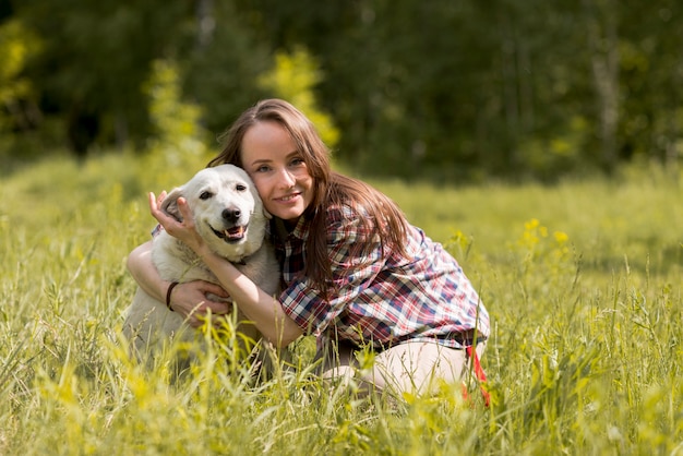 Mujer disfrutando con un perro en el campo