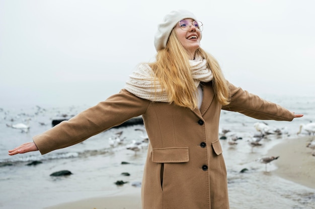 Foto gratuita mujer disfrutando de la playa en invierno