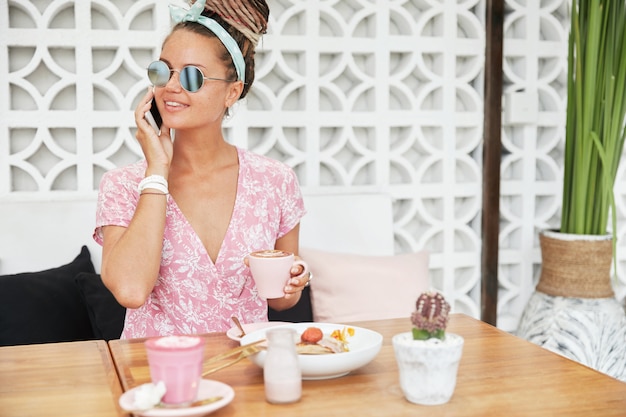 Mujer disfrutando de postre y bebida en la cafetería