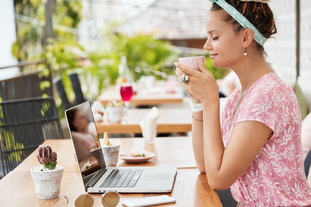 Mujer disfrutando de postre y bebida en la cafetería