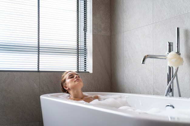 Mujer disfrutando de un relajante baño de burbujas