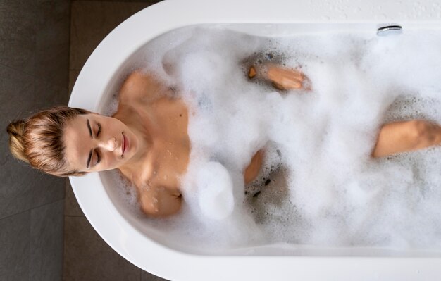 Mujer disfrutando de un relajante baño de burbujas