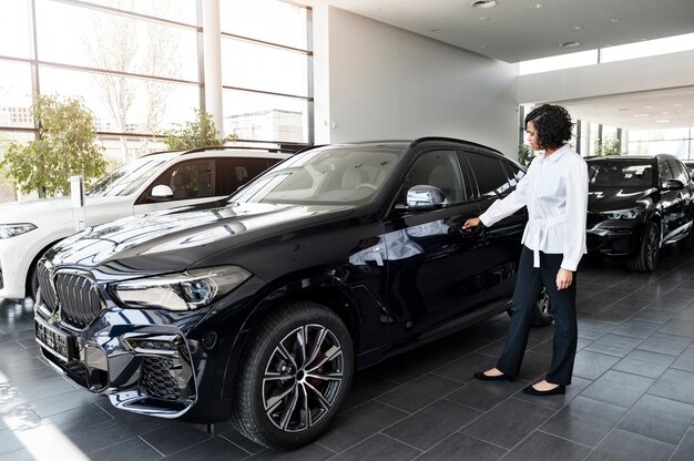 Mujer disfrutando de su independencia financiera mientras compra un coche