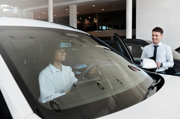 Foto gratuita mujer disfrutando de su independencia financiera mientras compra un coche