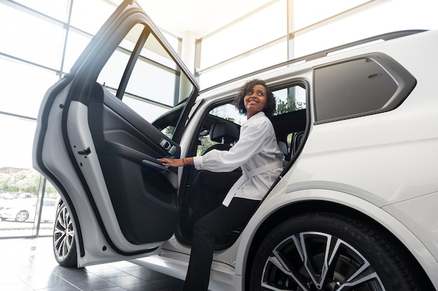 Mujer disfrutando de su independencia financiera mientras compra un coche