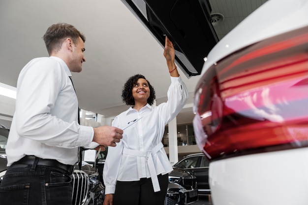 Foto gratuita mujer disfrutando de su independencia financiera mientras compra un coche