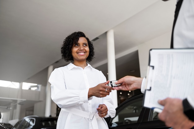 Mujer disfrutando de su independencia financiera mientras compra un coche