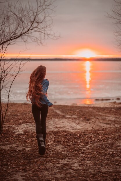 Mujer disfrutando de tiempo relajante junto al hermoso lago al amanecer