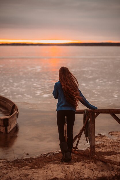 Mujer disfrutando de tiempo relajante junto al hermoso lago al amanecer