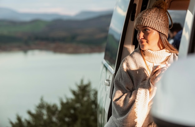 Mujer disfrutando de la vista de la naturaleza desde el coche durante un viaje por carretera