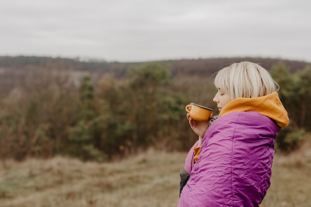 Foto gratuita mujer disfrutando de vistas de la naturaleza con una taza de té
