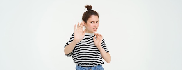 Foto gratuita mujer disgustada da un paso atrás levantando las manos defensiva evitando algo rechazando y rechazando la oferta