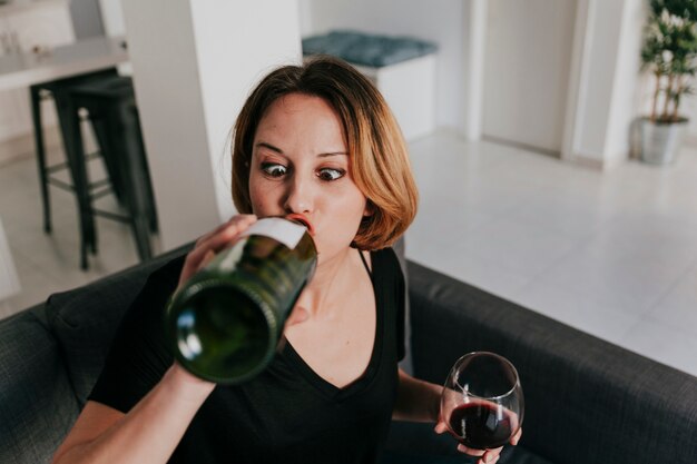 Mujer divertida bebiendo de la botella