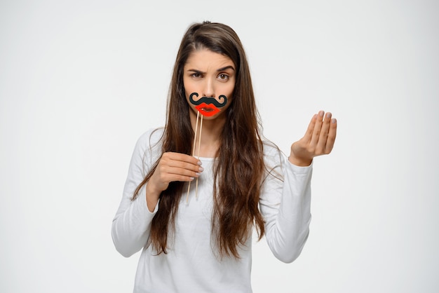 Mujer divertida haciendo muecas con bigote falso y labios