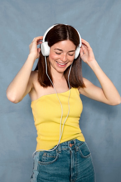 Mujer divirtiéndose con auriculares de tiro medio