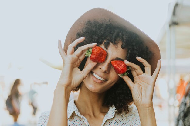 Mujer divirtiéndose con fresas