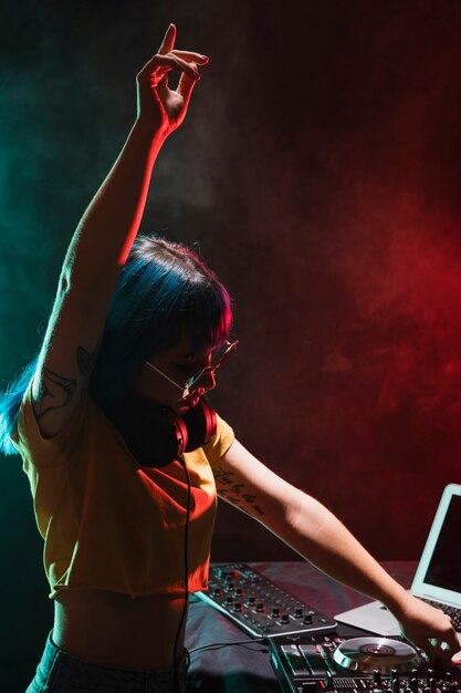 Mujer de DJ de alto ángulo en el panel de control