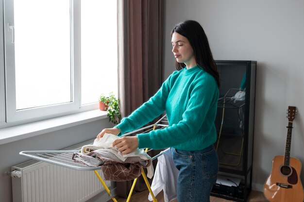 Mujer doblando toallas en casa durante la cuarentena