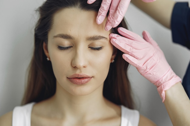 Mujer con un doctor en estudio de cosmetología