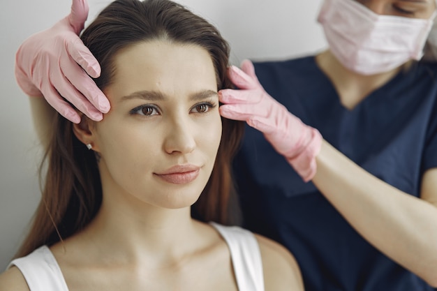 Foto gratuita mujer con un doctor en estudio de cosmetología