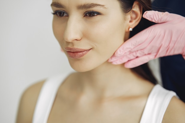 Mujer con un doctor en estudio de cosmetología