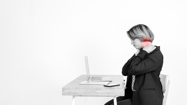 Mujer con dolor de cuello usando laptop