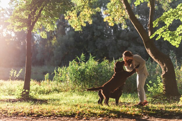 Mujer y dos perros jugando en el parque