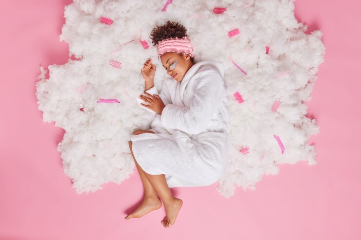 Foto gratuito mujer duerme tranquilamente ve dulces sueños se duerme después de caminar al aire libre soñando despierto en la nube viste una cómoda bata de baño