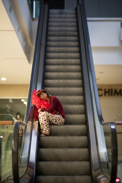 Foto gratuita mujer durmiendo en las escaleras del centro comercial