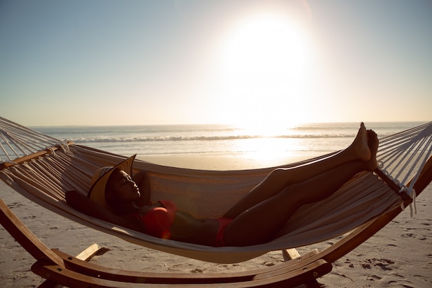 Mujer durmiendo en una hamaca en la playa