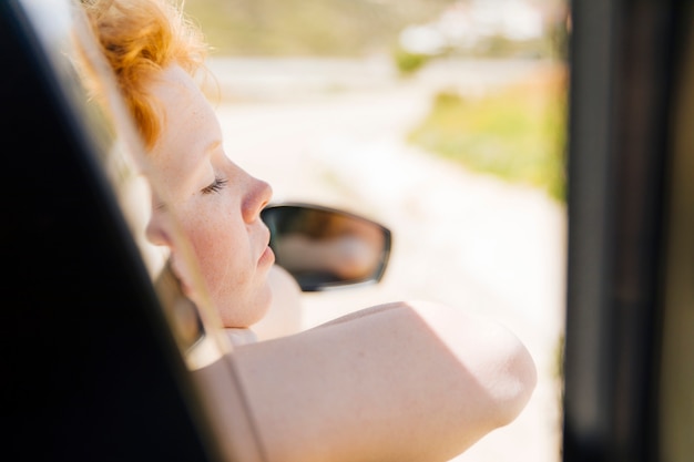 Mujer durmiendo en la ventana del coche