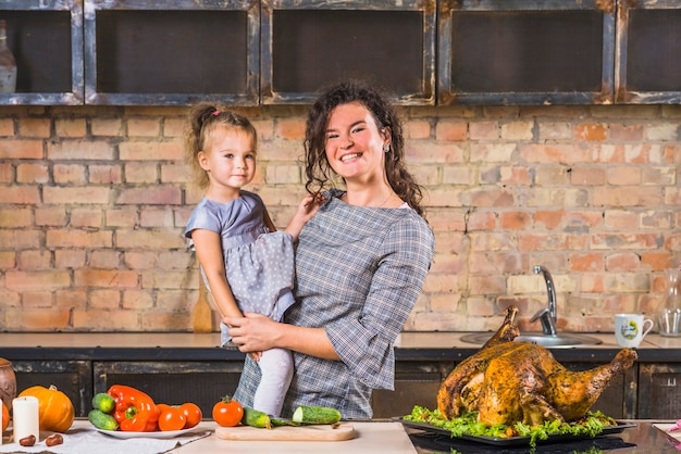 Mujer e hija en la mesa con pavo