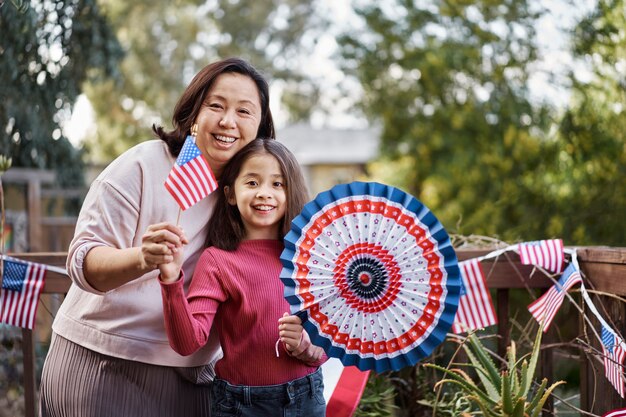 Mujer e hija de tiro medio celebrando el 4 de julio.