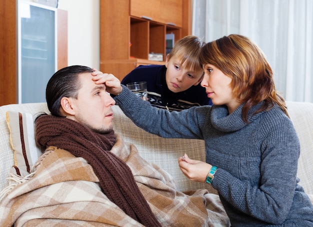 Mujer e hijo que cuidan al hombre enfermo