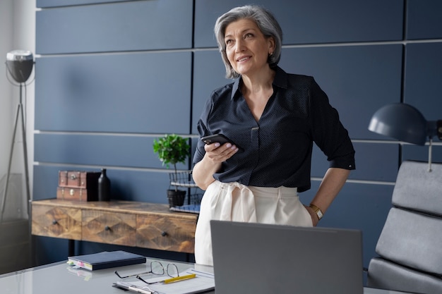 Foto gratuita mujer económicamente independiente en su oficina