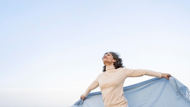 Mujer de edad disfrutando de su tiempo en la playa