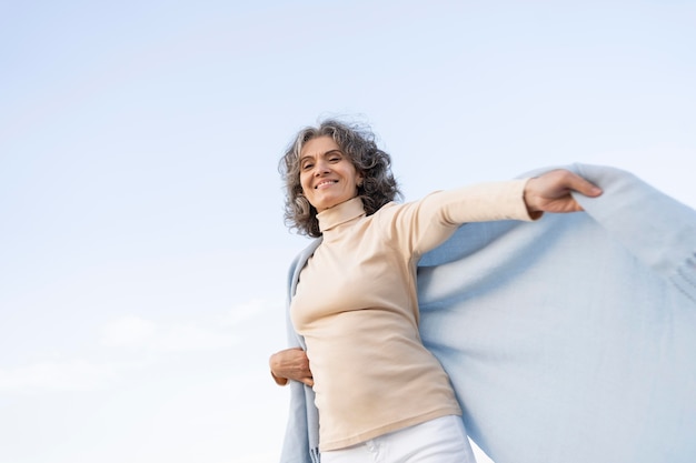 Mujer de edad disfrutando de su tiempo en la playa