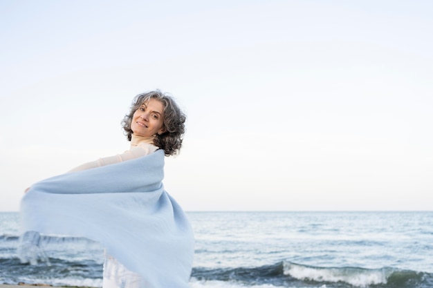 Mujer de edad disfrutando de su tiempo en la playa