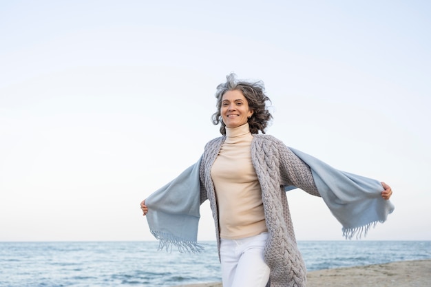 Mujer de edad disfrutando de su tiempo en la playa