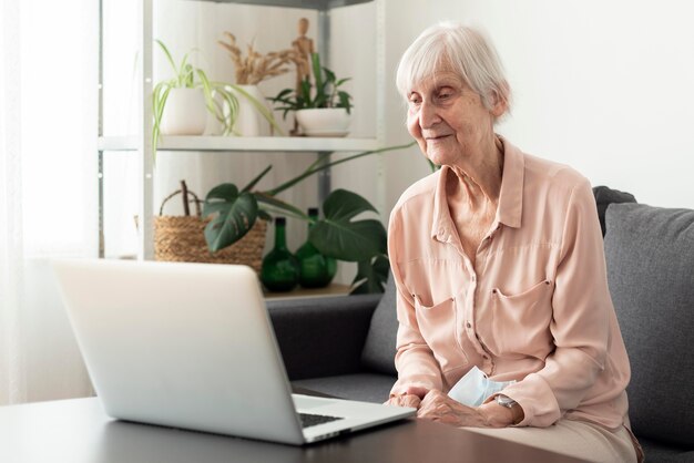 Mujer de edad con laptop en hogar de ancianos