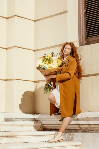 Mujer elegante al aire libre con ramo de flores de primavera